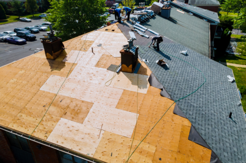 Replacement roofing company Ann Arbor shares an image of a roof being replaced on a home.