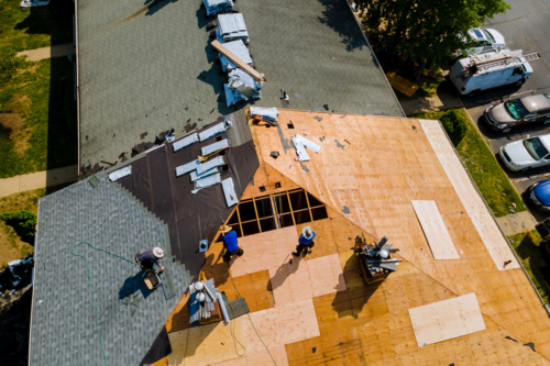 Replacement roofing company Ann Arbor shares an image of a roof being replaced on a home.
