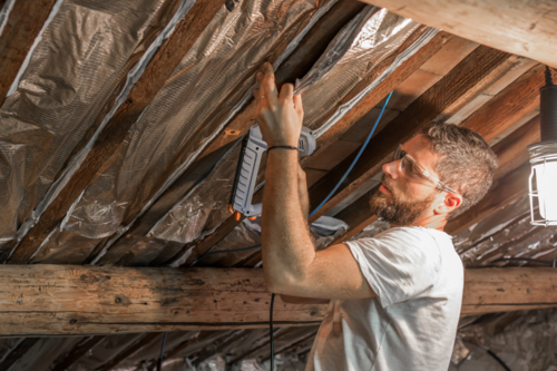 Man working for a roofing company to inspect attic health